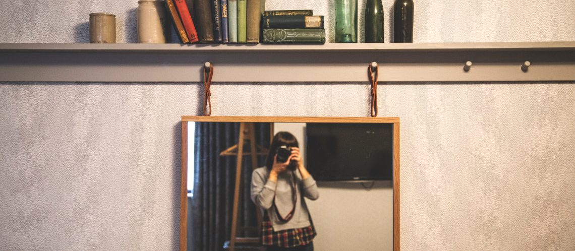 Frau fotografiert sich vor dem Spiegel