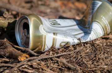 Müll zerbeulte Bierdose auf dem Boden soll auf Notwendigkeit der Müllvermeidung hinweisen