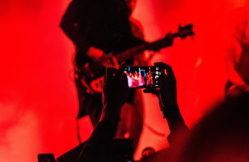 Gitarrist und Musiker auf Bühne mit Smartphone gefilmt zum Artikel: Jeden Tag ein neues Musikvideo dank künstlicher Intelligenz