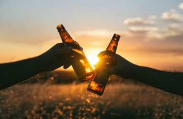Zwei Bierflaschen stoßen an vor dem Sonnenuntergang zum Artikel Top 10 September Events in Berlin
