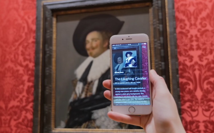 Museen digital: Smartphone wird vor Gemälde gehalten