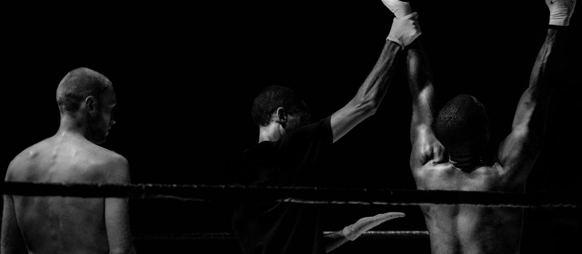 Schwarz-weiß Bild zwei Boxer, Schiedsrichter hält einen Arm hoch, Bild zum Wahlkampf 2017 Artikel