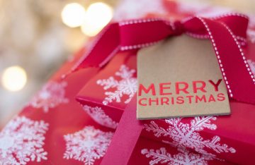 rotes Geschenk Schneeflocken Papierschild Merry Christmas zum Artikelthema Digital XMAS: Wie feiert Deutschland Weihnachten?