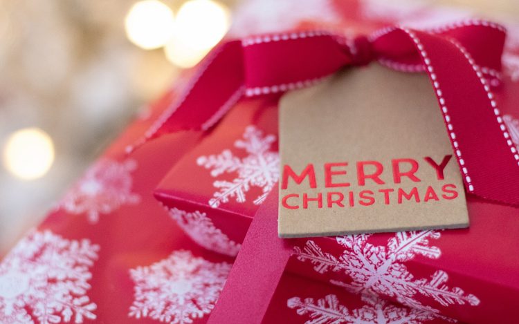 rotes Geschenk Schneeflocken Papierschild Merry Christmas zum Artikelthema Digital XMAS: Wie feiert Deutschland Weihnachten?