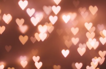 rosa Herzen dunkelroter Hintergrund zum Artikelthema Valentinstag: Top 5 außergewöhnliche Geschenkideen